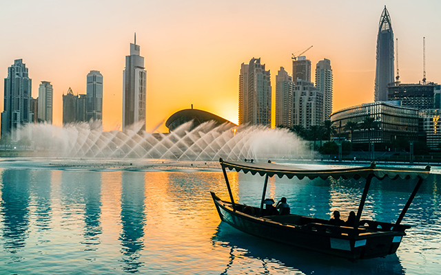 a boat on the water with a fountain in the background